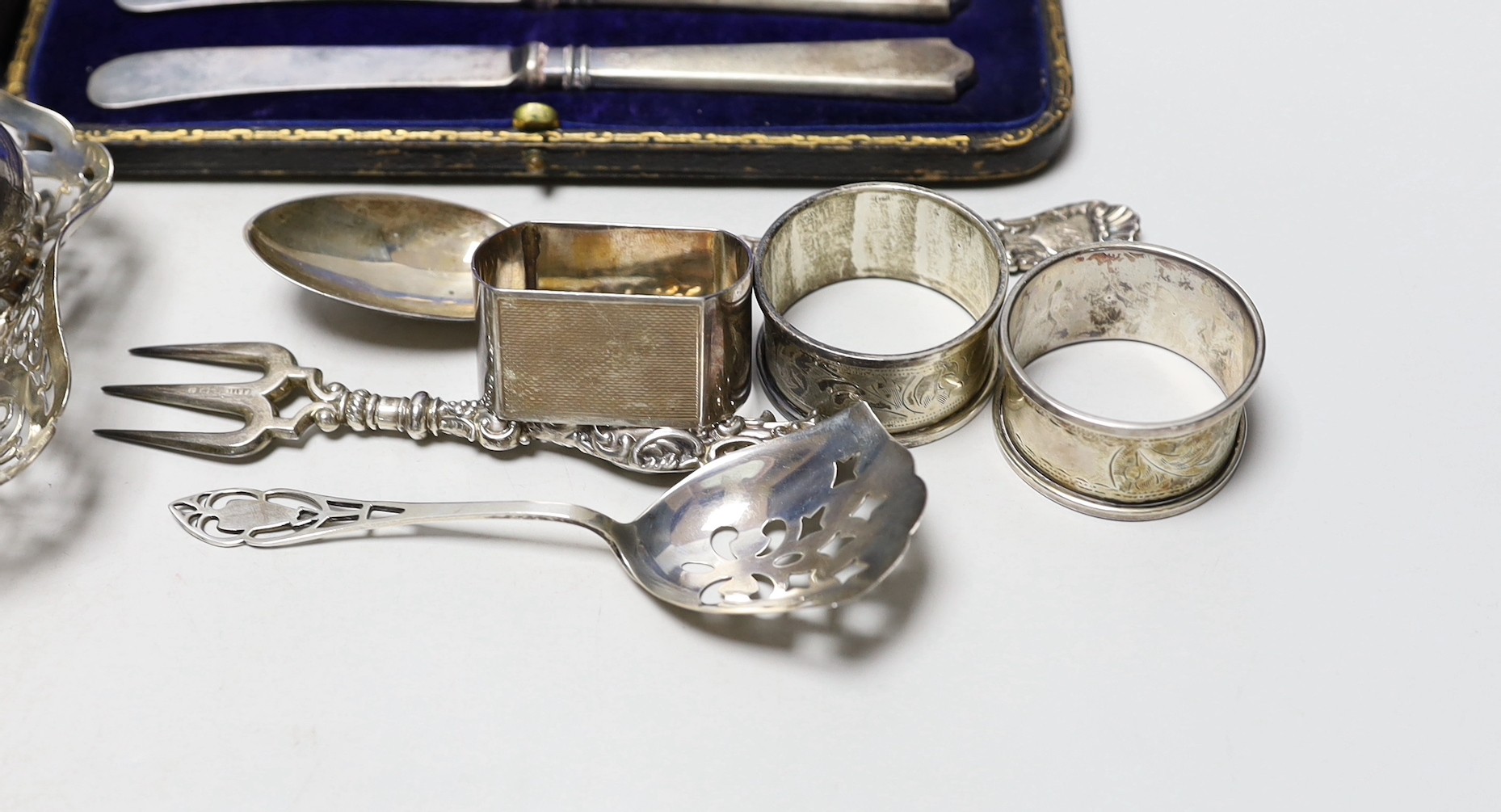 Sundry silver items including pierced shallow dish, cased handled tea knives, sterling mounted diary, cigarette case, seven napkin rings, cream jug and three items of cutlery.